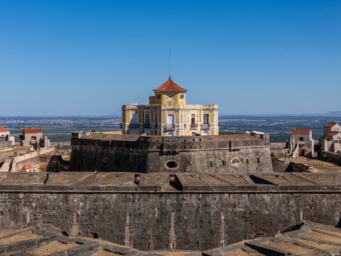 Elvas, Portugal - 10 September 2026: Aerial view of Forte de Nossa Senhora da Graca, a historic star-shaped fortress with stone walls and a central yellow building under a clear blue sky.