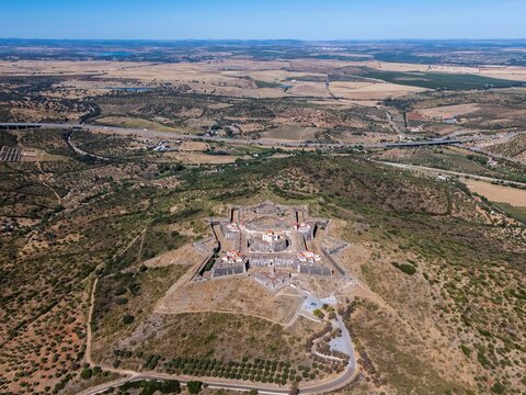 Elvas, Portugal - 10 September 2026: Aerial view of Forte de Nossa Senhora da Graca, a star-shaped historic fortress on a hilltop surrounded by dry landscape and rolling hills.