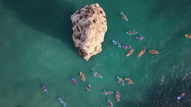 Aerial view of kayakers paddling around sea stack at marinha beach