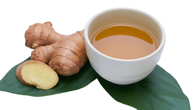Isolated fresh ginger root, cut slice, and a cup of aromatic herbal tea on a green leaf