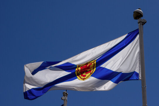 Nova Scotia provincial flag waving against a blue sky