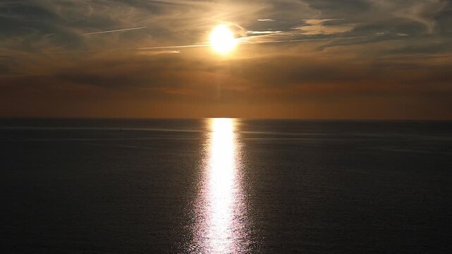 Golden sun reflecting over the calm Baltic Sea at sunset