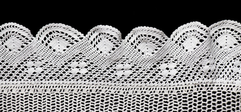 Crochet lace patterns border, crocheted Grandma's Doily corner, detail of hand-crocheted embroidery, tablecloth, napkin isolated on black background border art design. Craft, vintage linen. Flat lay