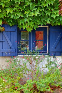 Maison aux fen&ecirc;tres et volets bleus en 