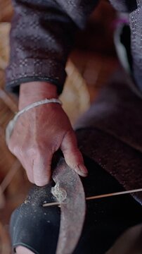 Guiyang, Guizhou, China - 03 September 2026: View of a person's hand using a metal tool to carve or shape a thin strip of bamboo.