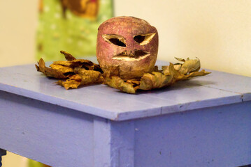 Traditional carved turnip lantern on autumn leaves and blue table for Samhain Halloween © RayBreen