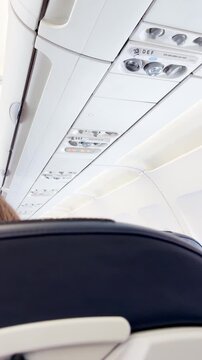Passengers seated in airplane cabin during flight with bright interior
