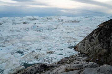 Arctic nature landscape with icebergs in Greenland icefjord with midnight sun sunset or sunrise in the horizon. Photo of ice. Ilulissat Icefjord with icebergs from glacier. © Maridav
