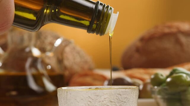 Olive oil extra virgin, Chef pouring fresh olive oil over Mediterranean table with olives and bread