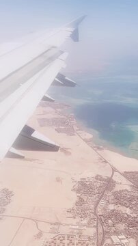 Aerial view of coastal desert and ocean from airplane window