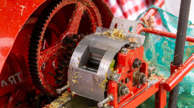 Close-up shot of the gears and mechanical components of a red sugarcane press machine