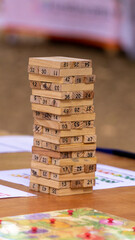 Vertical close-up shot of a wooden block stacking tower game with numbered blocks on a table © RRestrepo