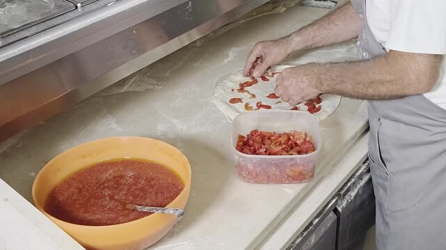 pizzaiolo prepara una pizza con i condimenti
