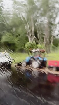 Rainy day view: blurred van and tree through wet glass window