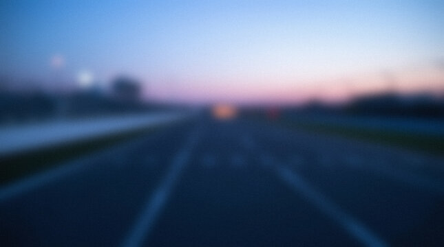 Blurred highway at dusk with soft pink and blue sky.