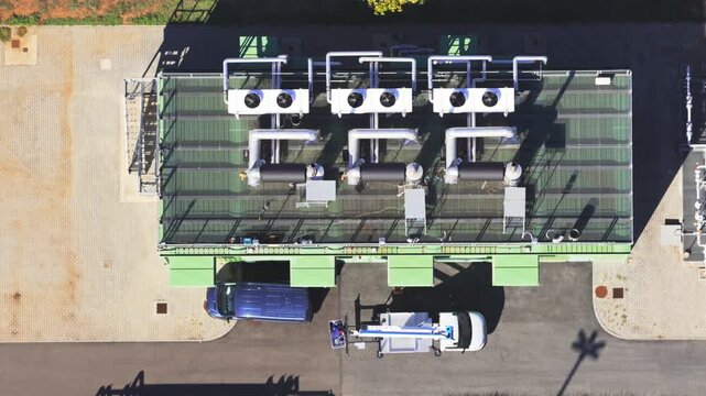 Aerial view of Snam Rete Gas Spa Centrale Spinta Gallese industrial facility with rooftop cooling equipment and maintenance vehicles in Gallese, Lazio, Italy.