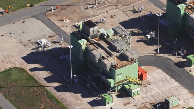 Aerial view of the Snam Rete Gas compression station facility featuring industrial machinery, piping, and paved grounds in Gallese, Lazio, Italy.