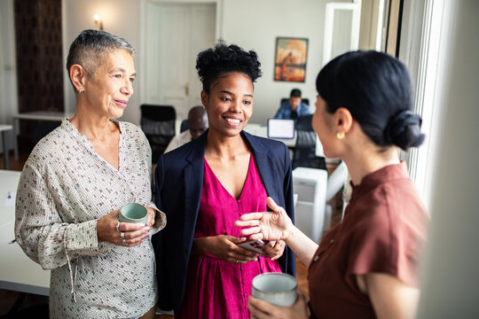 Three businesswomen networking during coffee break in modern office