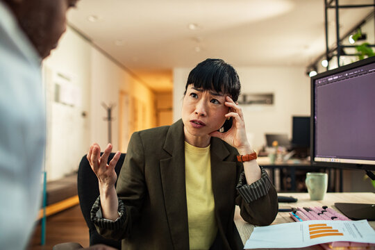 Female manager discussing project with colleague in modern office