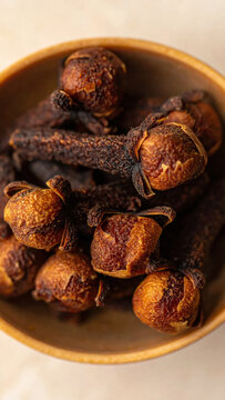 Bowl of dried spiced fruit with rough brown texture and warm earthy color, arranged as rustic culinary ingredient for cooking, seasoning, and traditional food preparation