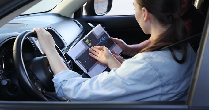 Driving school. Instructor teaching student how to drive through uncontrolled intersection on scheme in car, closeup