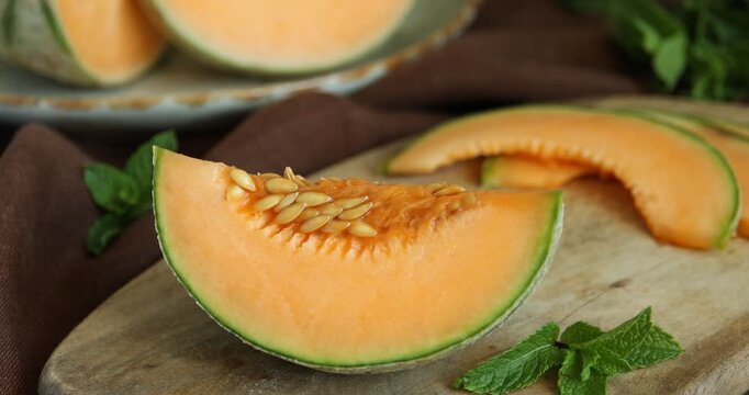 Woman taking piece of Cantaloupe melon from wooden table, closeup