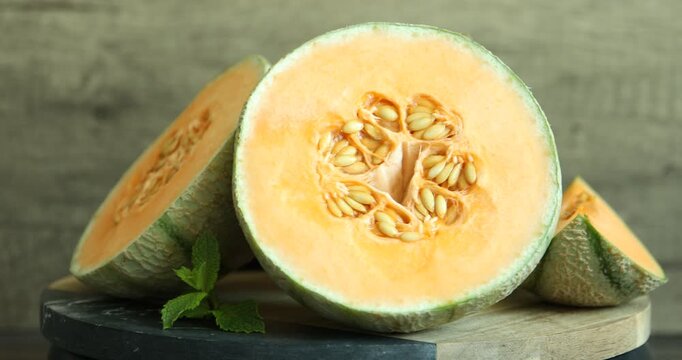 Fresh ripe Cantaloupe melons and mint on table, closeup