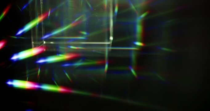 Light ray shining through a prism for angled beams of sparkling shine in brilliant colors. Swirling reflective glass with beaming lights creating visual effect of a brilliant dazzling rainbow. Loop.