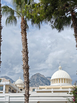 White domed buildings under cloudy sky with mountains