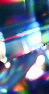 Light reflecting glass in brilliant saturated colors. Radiant lighting through a prism cube creating a visual of a colorful rainbow effect of light refraction. Spinning geometric abstract background.