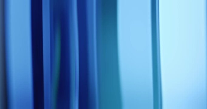 Radiant blue lights illuminate the brilliance of moving reflective glass creating a gradient of soft blues for a calm, relaxing aura. Smooth dreamy blue lighting abstract background or wallpaper Loop