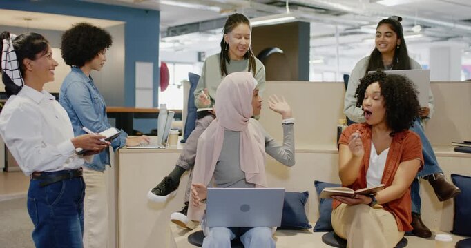 Diverse team watching woman in pink scarf opening meeting at office, gesturing with laptop