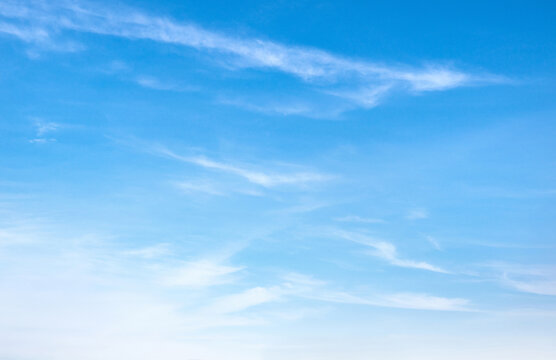 Clear blue sky with wispy clouds floating gently