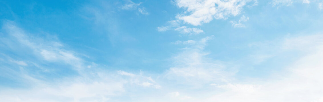 Soft clouds drift across  clear blue sky