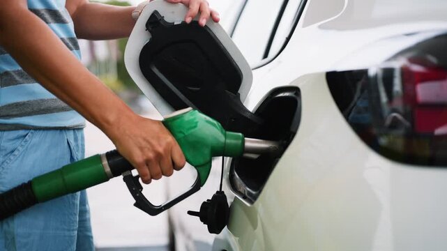 Woman pumping high price gasoline at station