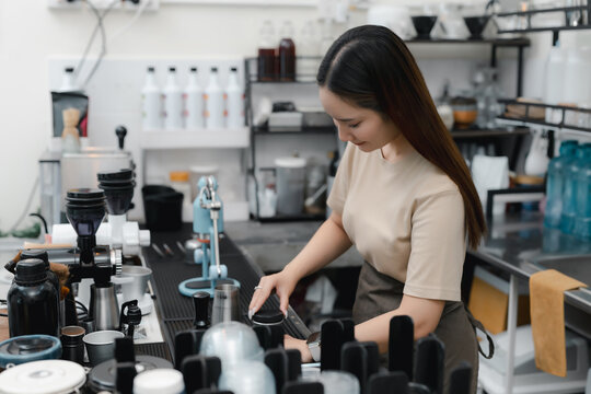 Espresso preparation concept. women barista tamping ground coffee at a cafe counter for precise brewing, coffee, barista, espresso, tamping, cafe.