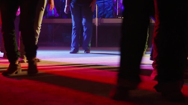 Boots Dancing to Country Music Under Colorful Stage Lights