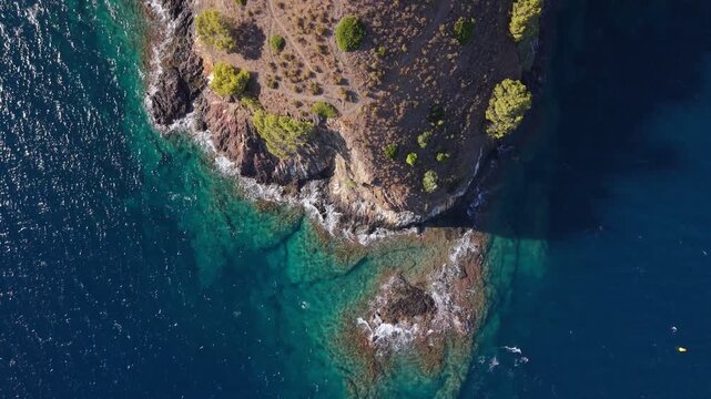 Aerial drone view of the rugged coastline at Cala Montjoi on Spain&rsquo;s Costa Brava, featuring rocky cliffs, clear Mediterranean waters and a scenic coastal landscape