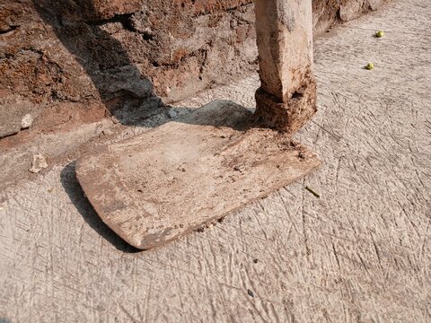 Traditional Gardening Hoe Tool with Wooden Handle on Concrete Ground