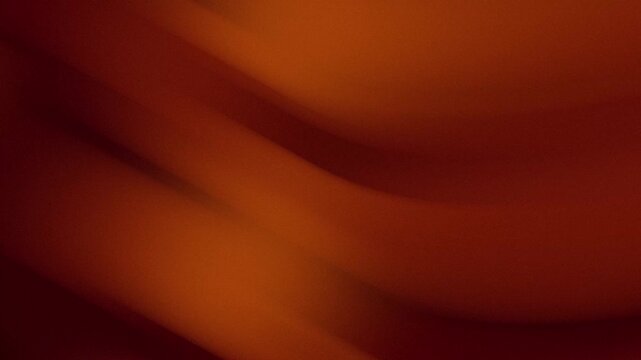 Abstract smooth flowing gradient background with warm red and orange tones in a blurred motion