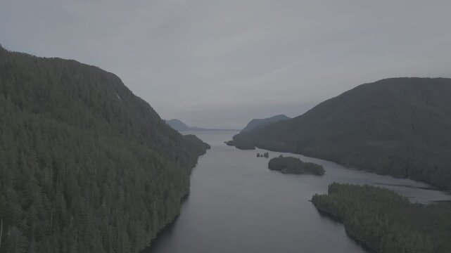 Aerial view of forested islands in a calm coastal fjord on the British Columbia coast &mdash; looking out toward open water