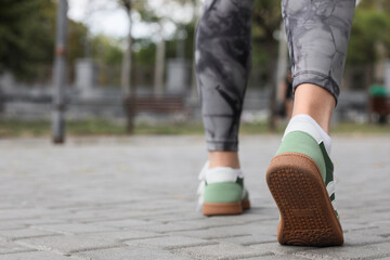 Fototapeta premium Healthy lifestyle and fitness, person walking in sneakers on city pavement for daily exercise and active living in an urban outdoor environment