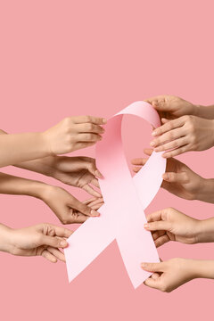Breast cancer awareness and community support, diverse hands holding a pink ribbon for health advocacy and medical solidarity on a soft pink background