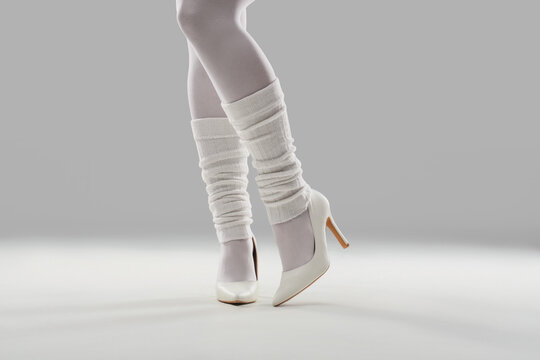 Fashion and dance style, woman wearing white high heels and leg warmers for retro aesthetic or ballet inspired look in studio