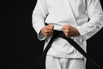 Young man practicing karate on dark background © Pixel-Shot
