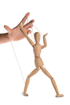 Hand of puppeteer manipulating marionette on white background