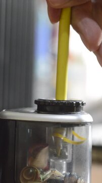 Close-up of an electric pencil sharpener and a colored pencil