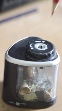 Close-up of an electric pencil sharpener sharpening a colored pencil.
