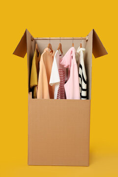 Wardrobe box with clothes on yellow background