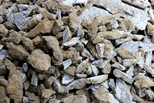 Close-up texture of crushed concrete rubble and stone debris from demolition.